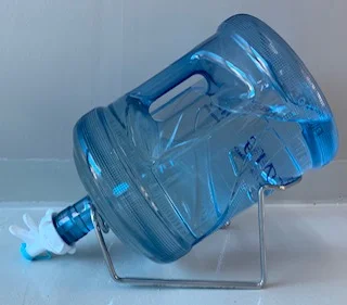 Hidden Spring bottle on a metal stand with manual dispensing tap